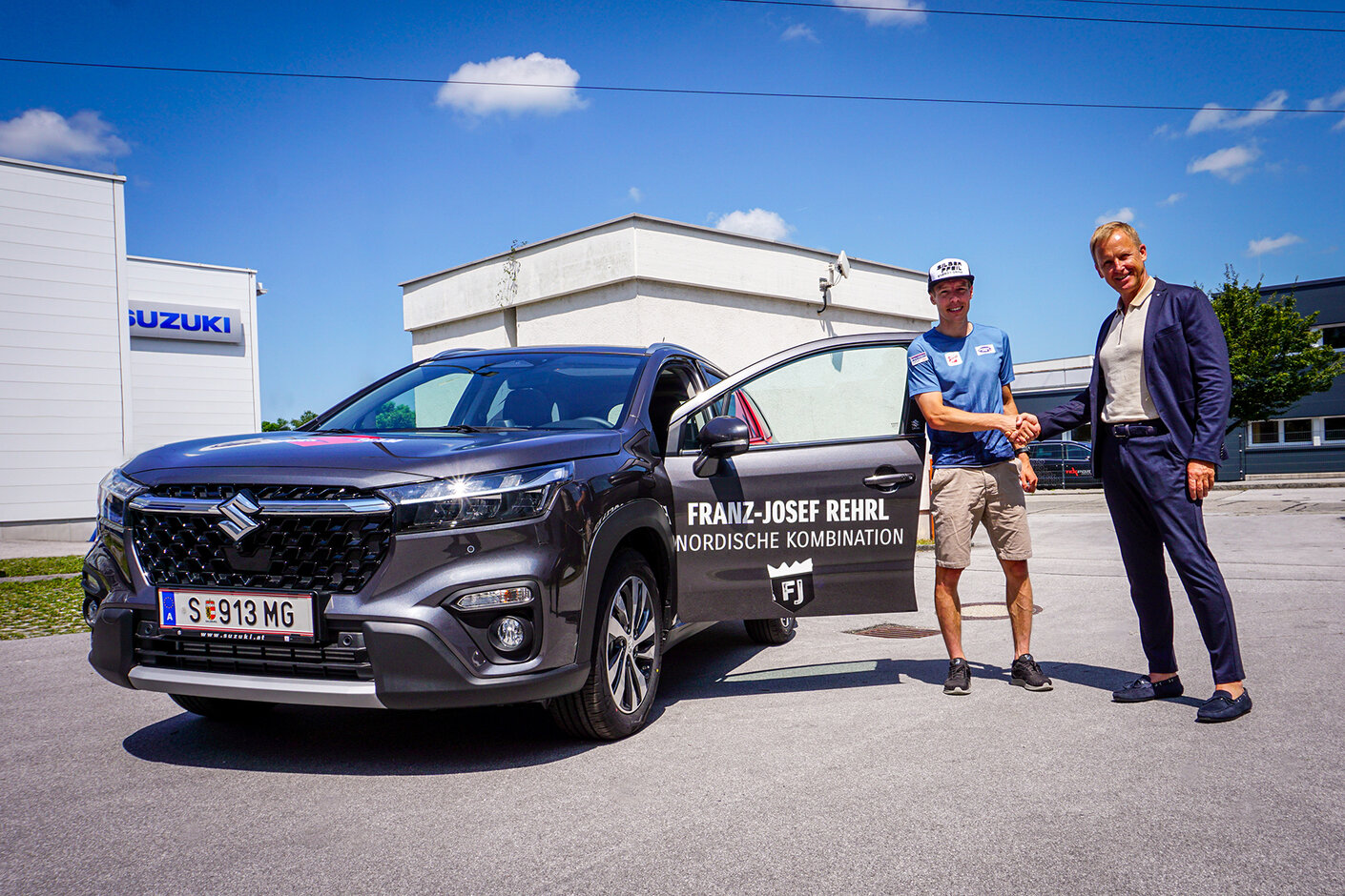 Roland Pfeiffenberger, Managing Director SUZUKI AUSTRIA, freut sich mit Franz Josef Rehrl über dessen Medaille und den neuen S-CROSS HYBRID.